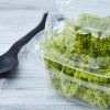 Recipiente plástico con ensalada encima