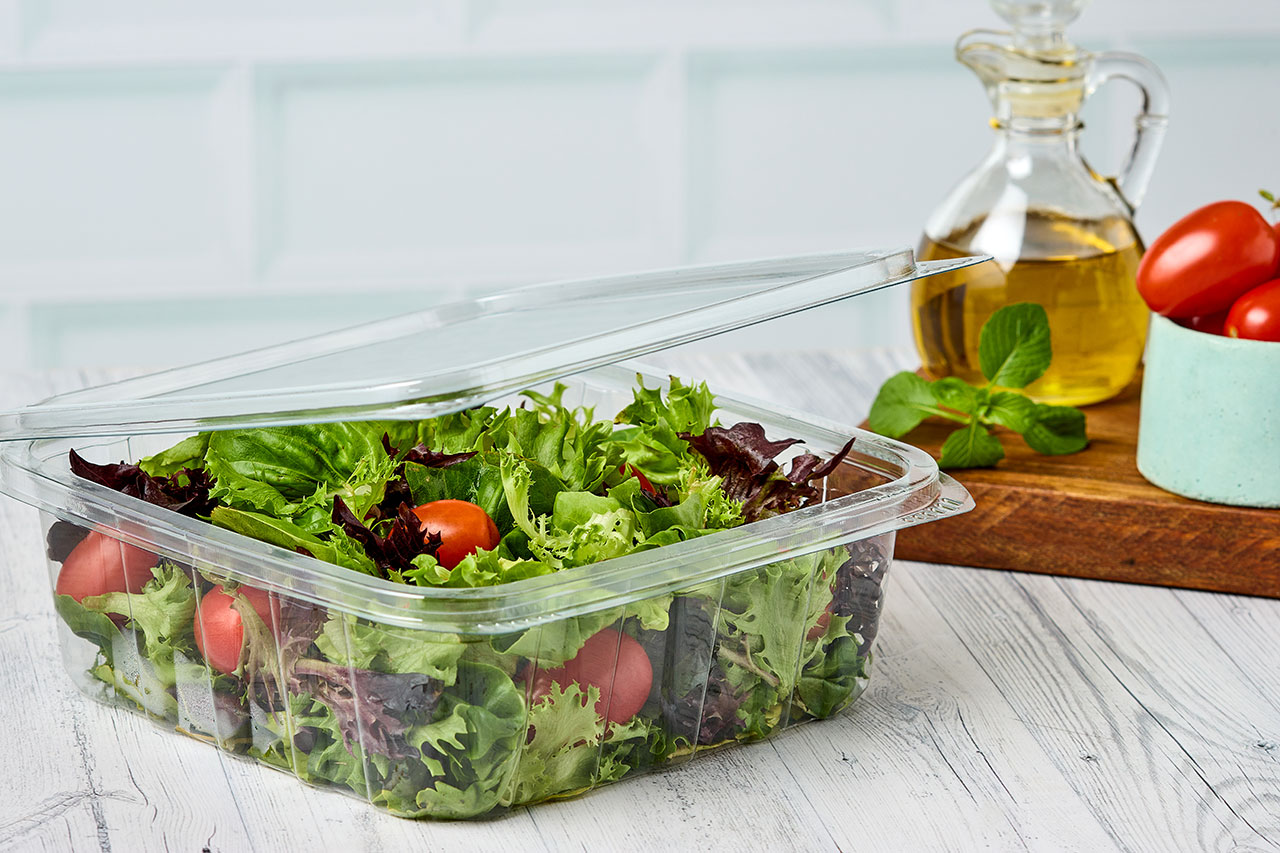 Recipiente plástico con ensalada encima